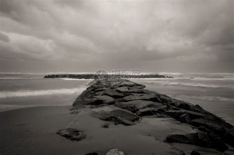 黑白的海滩上断水石黑暗的暴风天空和意大利拉齐奥的海浪高清图片下载-正版图片303673681-摄图网