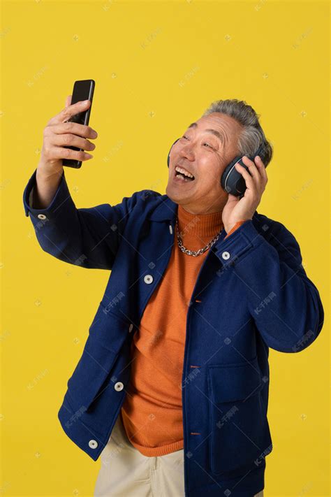 拿着手机看视频的快乐老人高清摄影大图-千库网