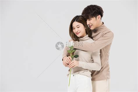韩系情侣亲密拥抱手拿玫瑰花高清图片下载-正版图片502357484-摄图网