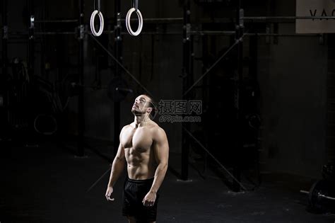 准备在黑暗体操场使用健身环的赤胸青年男子高清图片下载-正版图片501860190-摄图网