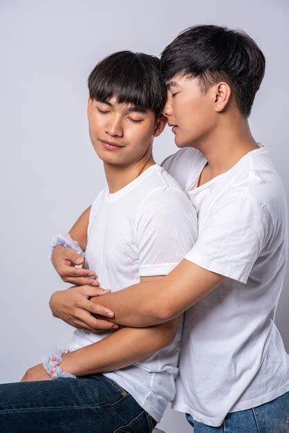 Free Photo | Two men who love each other hug from behind another.