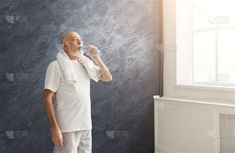 口渴的老人从瓶子里喝水