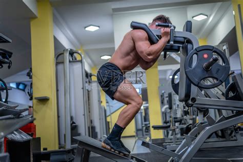 男子在健身房用深蹲机做股四头肌锻炼照片摄影图片_ID:428726907-Veer图库