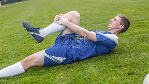 身着蓝色队服的足球运动员受伤躺在球场上照片摄影图片_ID:169219327-Veer图库
