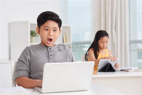 张开嘴看笔记本电脑监视屏幕的男孩震惊高清图片下载-正版图片503485331-摄图网