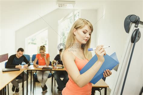 年轻女教师在白板前做笔记高清图片下载-正版图片305181181-摄图网