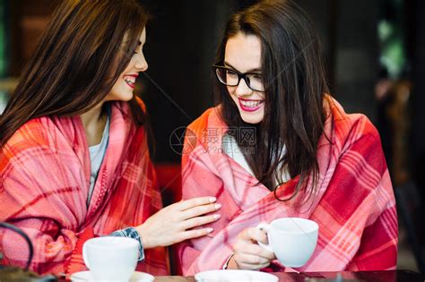 两个年轻美丽的女孩在阳台上闲聊喝杯咖啡高清图片下载-正版图片502771454-摄图网