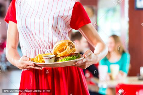 在美式快餐店，朋友或情侣在吧台上吃快餐，喝奶昔，女服务员穿着短装,摄影素材,汇图网www.huitu.com