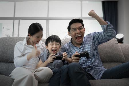 父母带着儿子在客厅看电视玩游戏高清图片下载-正版图片303568594-摄图网