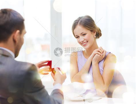 兴奋的年轻女人看着男朋友与订婚戒指餐厅高清图片下载-正版图片300812038-摄图网