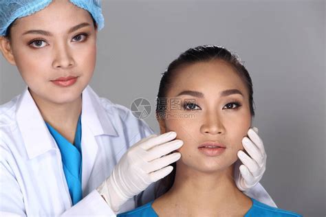 亚洲医生护士在整形手术前检查脸颊骨结构并向患者注射美容化学注射器高清图片下载-正版图片504382117-摄图网