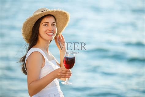 在海边拿着酒杯的女人照片摄影图片_ID:383080213-Veer图库
