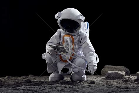 宇航员手拿平板电脑蹲在地上高清图片下载-正版图片502355547-摄图网