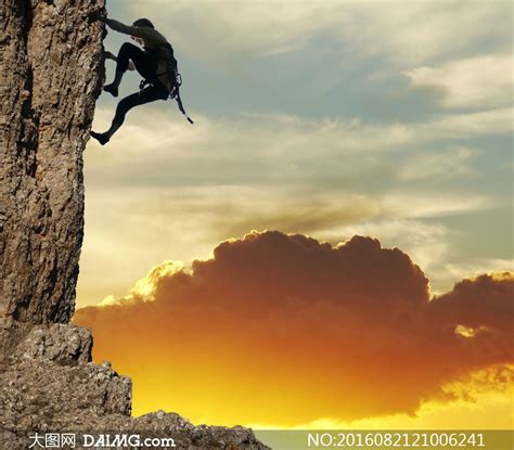 那位登山者爬上了山顶，一个徒步旅行者站在岩石的顶峰庆祝成功。照片摄影图片_ID:303929945-Veer图库