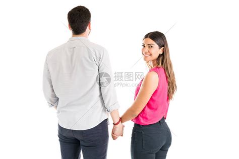 带着男朋友的手站在白人背景面前微笑着高清图片下载-正版图片504129201-摄图网