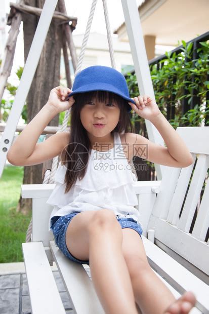 外部坐在摇摆手上的女孩拿着蓝色帽子笑蓝色的活动高清图片下载-正版图片308002720-摄图网
