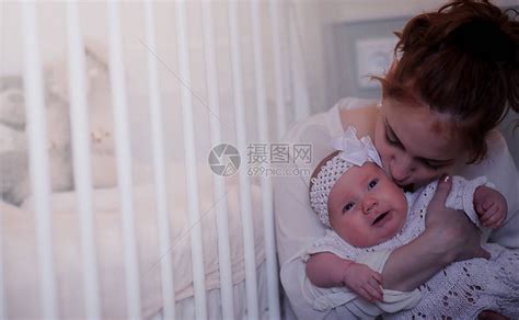 妈怀里抱着一个刚出生的婴儿女孩在窗前抱着一个婴儿母亲高清图片下载-正版图片506056903-摄图网