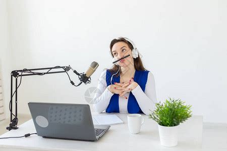 电台主持人概念作为电台主持人的女坐在工作室的白色背景高清图片下载-正版图片506196533-摄图网