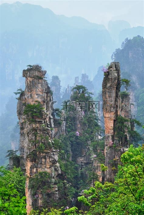 中国著名旅游胜地-中国湖南武陵源雾云中的张家界石柱悬崖山。高清摄影大图-千库网