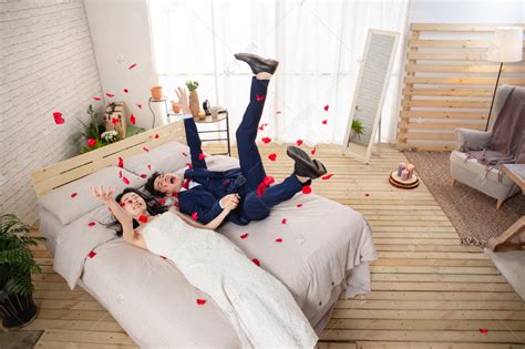 兴奋的新婚夫妇倒在床上高清摄影大图-千库网