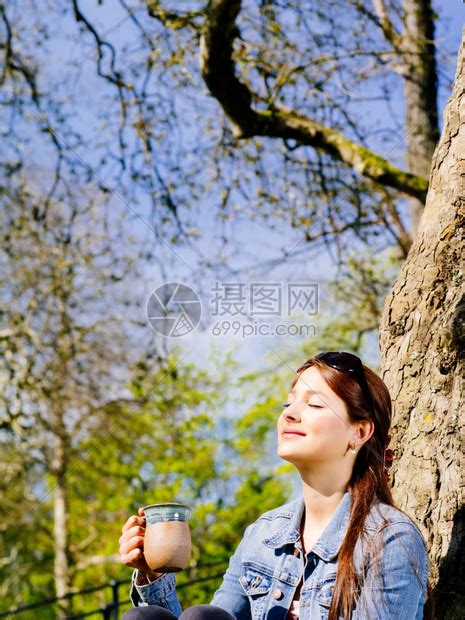 成人马克杯夏天一位美丽的年轻女子坐在户外享受阳光温暖时喝咖啡或茶的照片她脸被遮着高清图片下载-正版图片308023558-摄图网