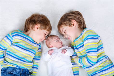 两个快乐的学龄前小男孩带着刚出生的女婴高清图片下载-正版图片502706276-摄图网
