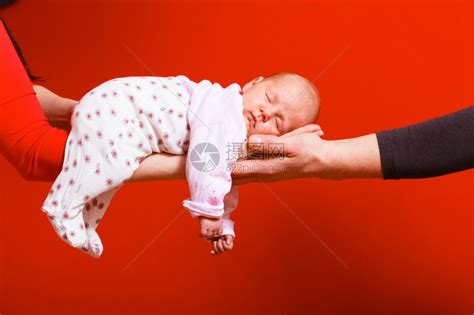 一个月大的女婴睡在父母怀抱红色背景的舒适中高清图片下载-正版图片304086526-摄图网