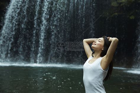站在小溪边享受瀑布的女人在舒展身体高清图片下载-正版图片502071640-摄图网