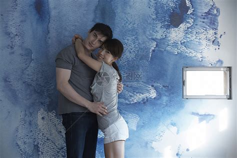 蓝色墙壁前看着镜头的情侣高清图片下载-正版图片502059979-摄图网