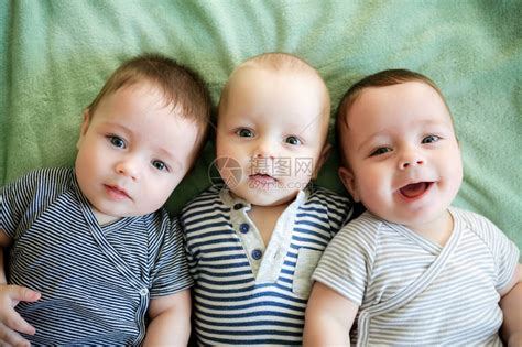 肖像的新生三胞胎正躺在床上高清图片下载-正版图片502443475-摄图网