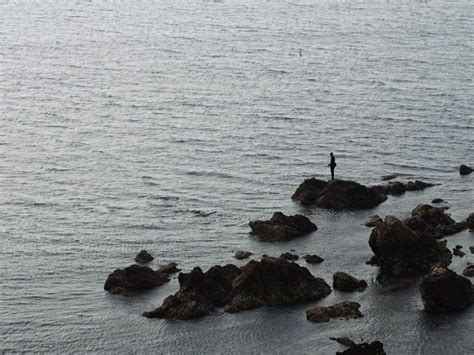 年轻的亚洲女人坐在悬崖上，望着远方的大海。美丽的女孩在海滩上眺望大海。 令人振奋的时刻 一个年轻女子眺望地平线的画像正版图库-素材下载-图蜗创意图片库