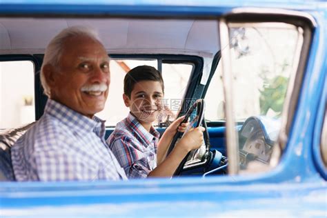 家庭和代沟老爷和孙子在一起他教开车这个男孩拿着一辆60年代的老爷车的volante他们都笑得很开高清图片下载-正版图片502702321-摄图网