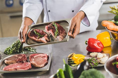 非洲人厨师在餐厅用生肉端着餐盘的高清图片下载-正版图片503411053-摄图网