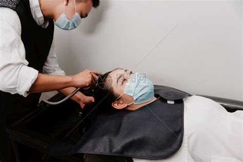 头发廊概念男理师拿着水淋浴的男子理发师轻清洗女顾客的头发型医疗造高清图片下载-正版图片308029919-摄图网