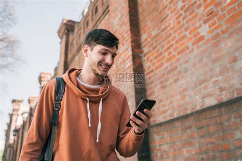 年轻帅哥用手机在街上户外拍摄的肖像高清图片下载-正版图片303669897-摄图网