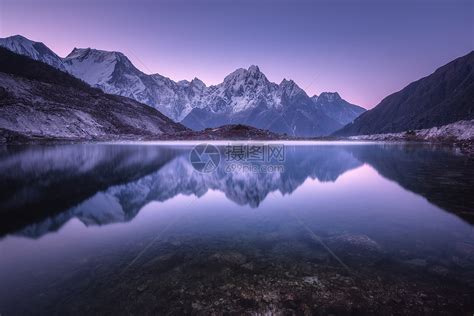 山湖日出时完美的倒影美丽的风景与紫色的天空,雪山,山丘,雾湖黄昏尼泊尔雪覆盖的岩石反射水中高清图片下载-正版图片300887137-摄图网