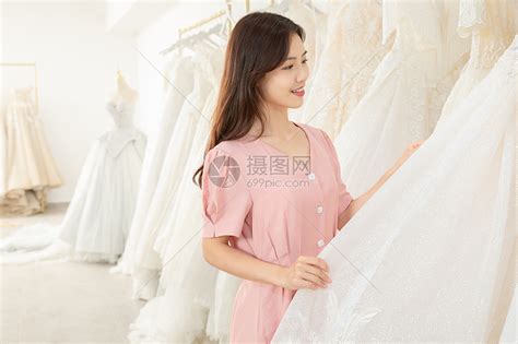 在婚纱店挑选婚纱的女孩高清图片下载-正版图片501654679-摄图网