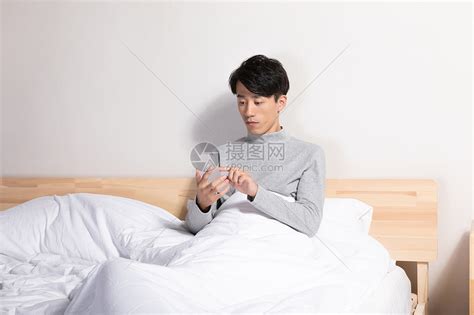 青年男性居家玩手机听音乐高清图片下载-正版图片501401151-摄图网