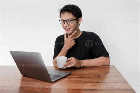 Young asian man is smile and enjoy when working at home with laptop and ...
