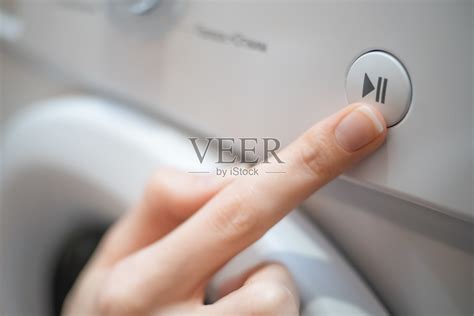 女孩的手按下了洗衣机控制面板上的开始、暂停按钮照片摄影图片_ID:372496353-Veer图库