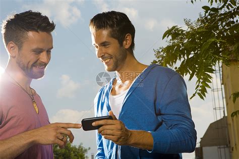 两个看着手机聊天的男人高清图片下载-正版图片501835885-摄图网