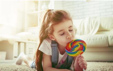 年轻女孩吃着一颗心形的棒糖高清图片下载-正版图片306933878-摄图网