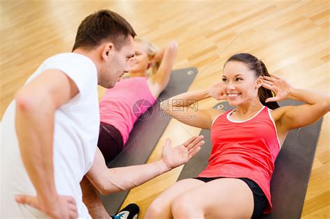 健身,运动,训练,健身房生活方式的群微笑的女人男教练健身房的垫子上仰卧坐高清图片下载-正版图片300748040-摄图网