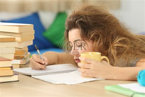疲倦和困倦的学生试图写笔记照片摄影图片_ID:168848990-Veer图库