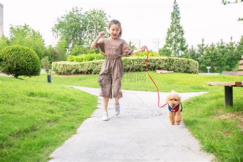 小女孩户外遛狗和狗玩耍高清图片下载-正版图片501397740-摄图网
