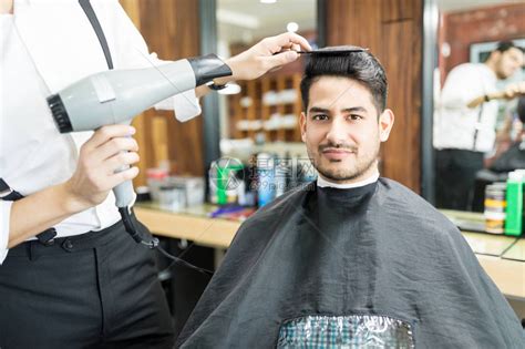理发师在美发店用理发机清洗客户高清图片下载-正版图片505389746-摄图网