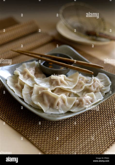 Zhong shui jiao, crescent dumplings, served on plate with soy dipping sauce and chopsticks Stock ...