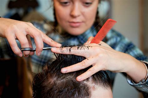 在美发店剪男人头发的女理发师高清图片下载-正版图片505019699-摄图网