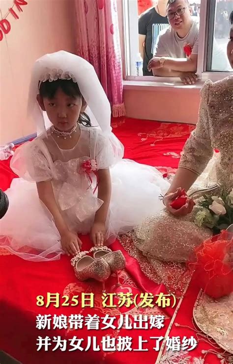 视频中，女孩的妈妈带着她即将出嫁。妈妈穿着新娘妆，打扮得极为精致。而在她身边坐着她的女儿。