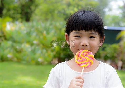 小女孩笑着吃棒糖高清图片下载-正版图片502698145-摄图网